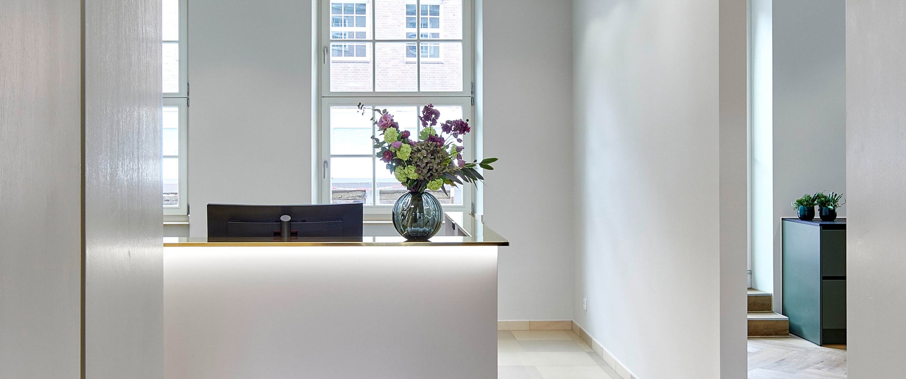 Empfangstresen einer Anwaltssozietät mit Blumen