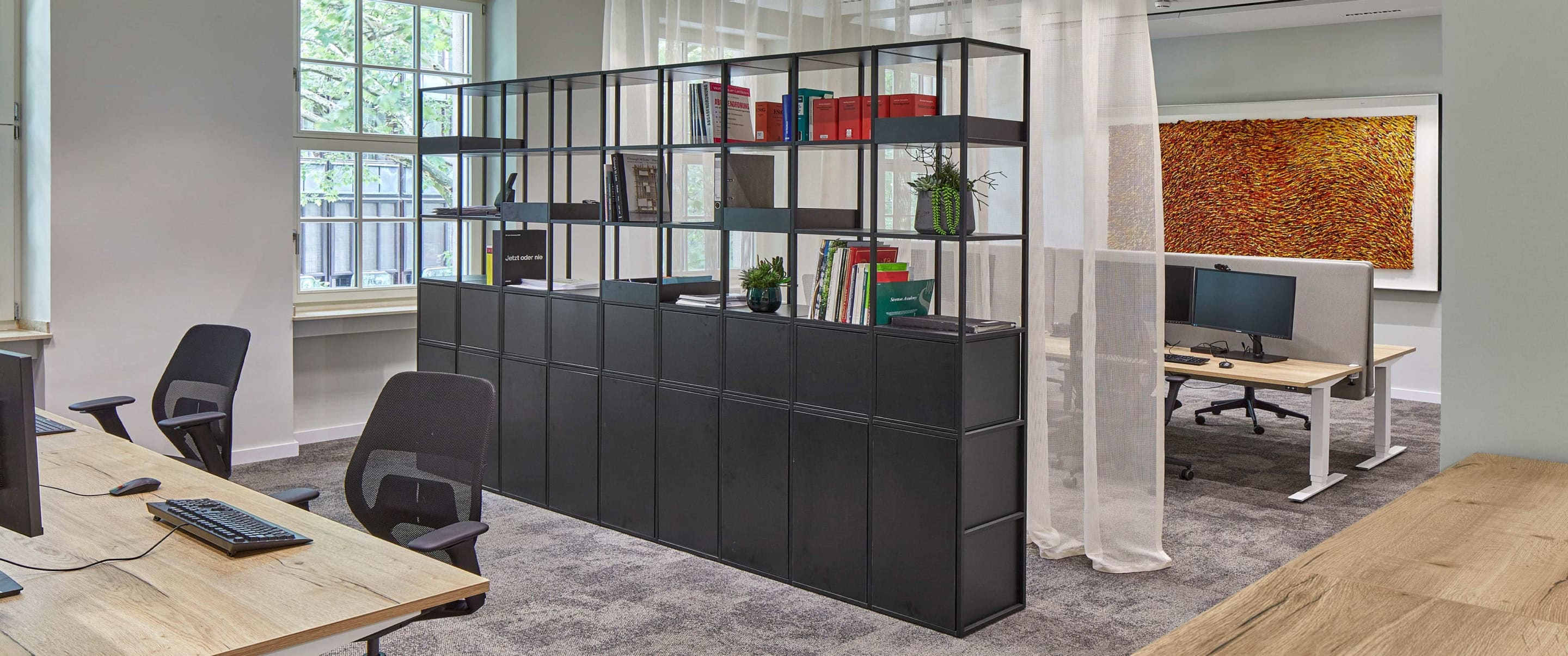 Schönes Office mit modernem Holzschreibtisch und Raumteiler der Sozietät Ganteführer